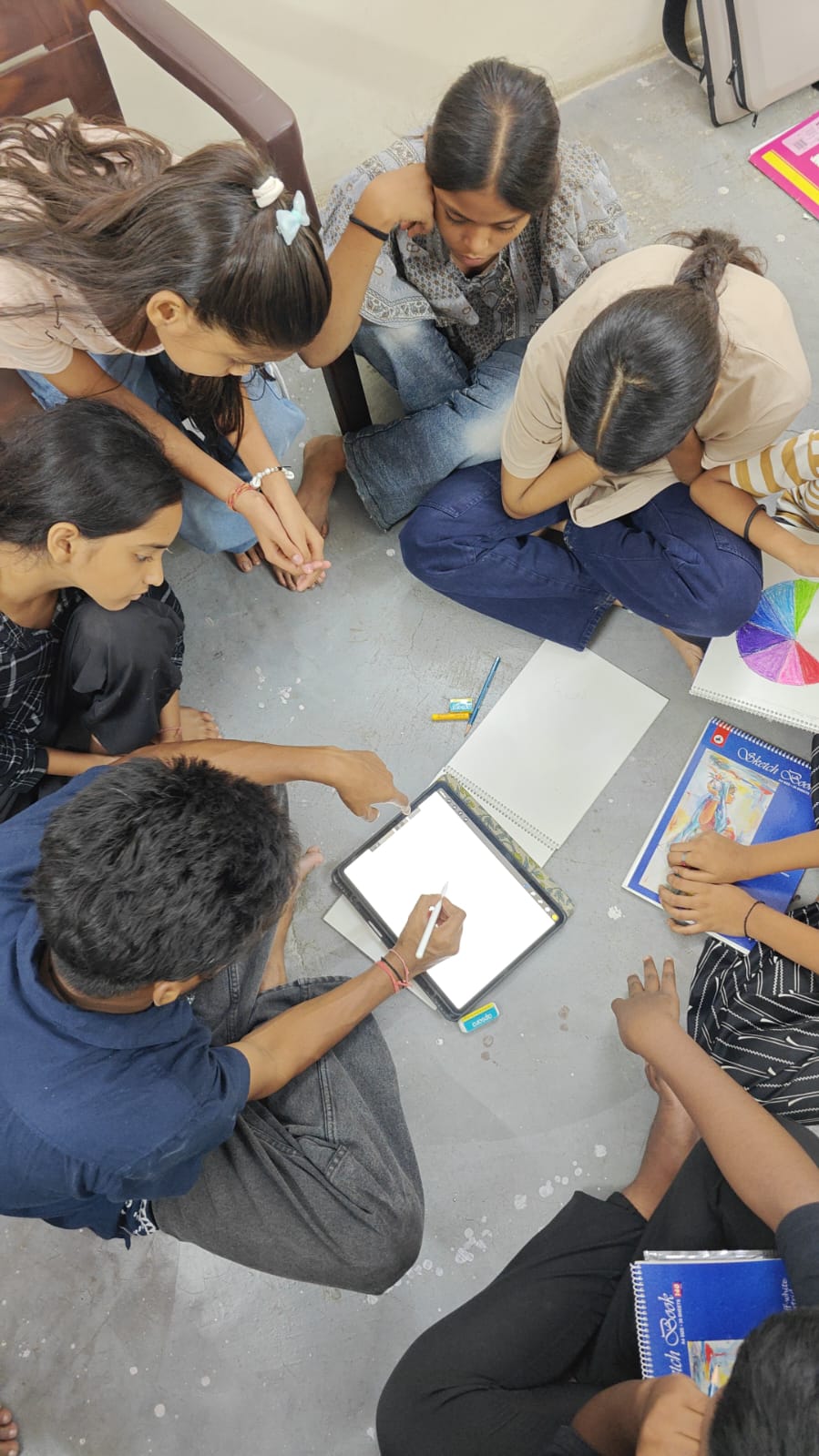Students gathered around a sketchbook